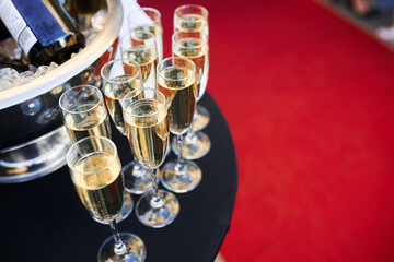 the waiter's hands pouring champagne on the summer terrace of a luxury restaurant