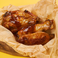 fried chicken wings on craft paper and yellow background