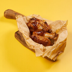 fried chicken wings on craft paper and yellow background