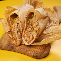 mexican burrito on craft paper and yellow background