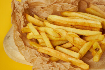 french fries on craft paper and yellow background