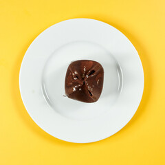 chocolate dessert on white plate and yellow background