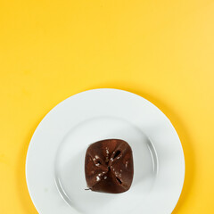 chocolate dessert on white plate and yellow background