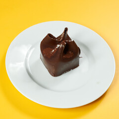 chocolate dessert on white plate and yellow background