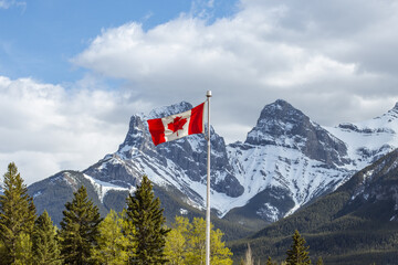 Canadian Flag with Three Sisters snowy Mountain Range in the Background