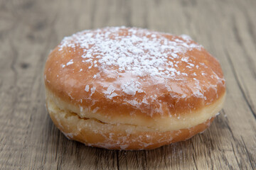 Lemon filled glazed donut is textured with powdered sugar coating for a sweet treat delight