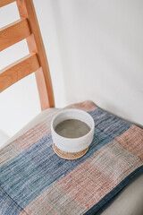 Matcha latte, Japanese green tea in white ceramic cup on wooden chair during traditional ceremony, closeup.