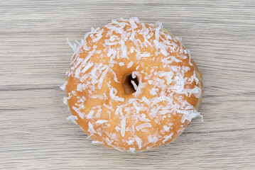 Overhead view of cocnut raised  donut is textured with glazed coating for a sweet treat delight