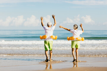 Senior couple running on the beach and show hands whitham enjoying, plan life insurance and...