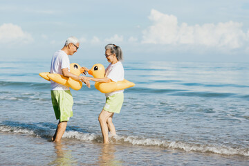 Romantic Senior couple strolling happily along the beach in the sunshine and bright sky. Plan life insurance and retirement concept.