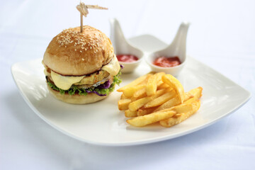 burger and fries with some sauce white background