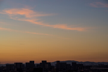 早朝神戸の高層マンション高層階より大阪方面。遠くに生駒山。雲と空がオレンジ色に染まる