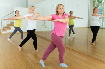 Fototapeta na wymiar Three European mature women are dancing in fitness room