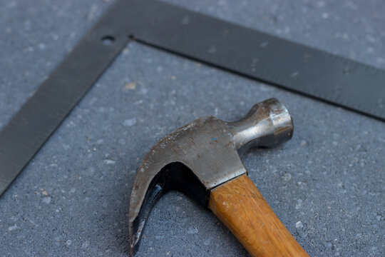 Hammer and metal square on stone background