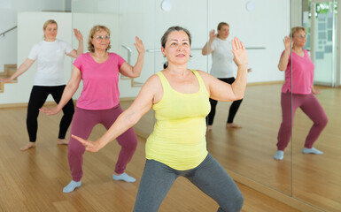 Happy adults training swing steps at dance class