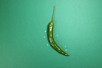 green chilli pepper on green background cut pieces seeds
