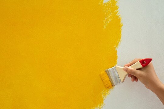 Do-it-yourself yellow paint plots on the walls of the house