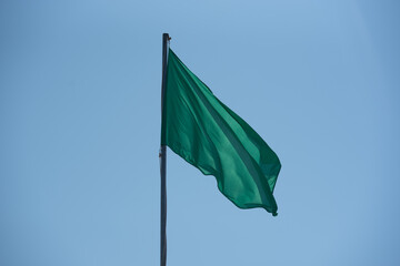 Green Flag in the Levante beach in Formentera, Spain in summer 2021.