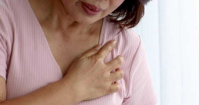 A senior woman suffered and pain from heart attack desease using hand holding chest on heart position. Concept of older person health care.