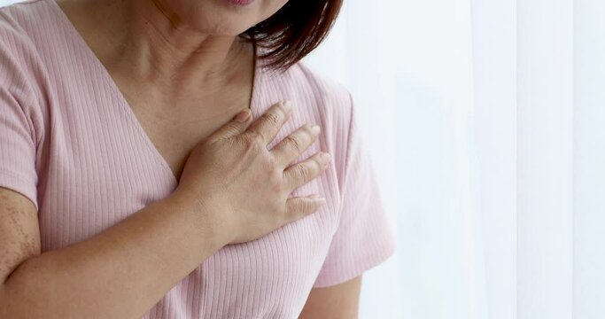A senior woman suffered and pain from heart attack desease using hand holding chest on heart position. Concept of older person health care.