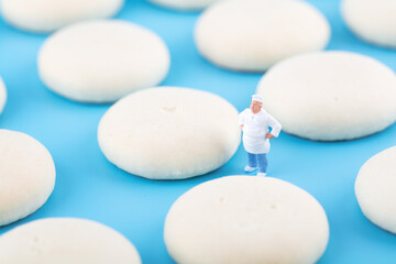 Pastry chef dolls and made biscuits on blue background