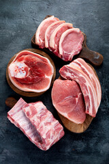 Different types of raw meat on black background