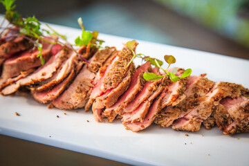 slides of meat served on a white dish