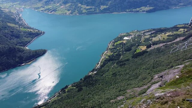 Fantastic view from mount Hoven Loen Nordfjord - Looking at Loen Skylift mast on mountain top before panning left and down to reveal Nordfjord and steep mountainside - Aerial Norway