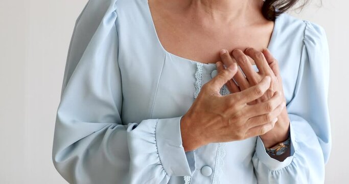 A senior woman suffered and pain from heart attack desease using hand holding chest on heart position. Concept of older person health care.