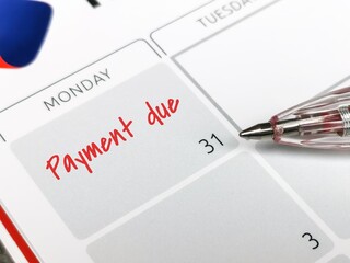 Reminder concept of payment. Close up text payment due written on calendar with a pen. Selective...