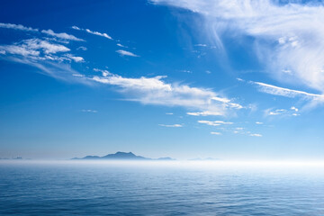 Sea landscape, sea surface. Blue sky, clouds, sunlight, rays. Empty natural scene in the open air. Blurred abstract background. Background of a sea landscape. Blue sky with clouds over the sea. - 446543763
