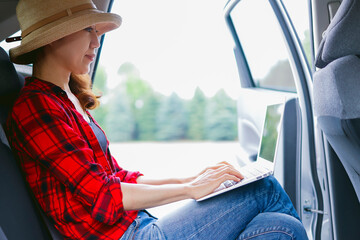 車とラップトップを見る女性