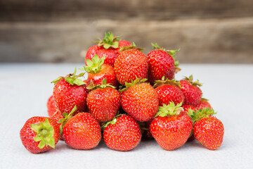 Heap of fresh red ripe strawberries on a wooden background