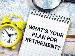 Text WHAT'S YOUR PLAN FOR RETIREMENT? writing on notebook with magnifying glass and clock on a wooden background.