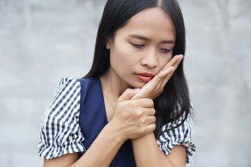 Fototapeta na wymiar Young Asian woman got toothache on gray background