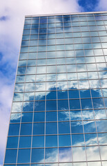 Reflection of sky with clouds in the glass building in downtown
