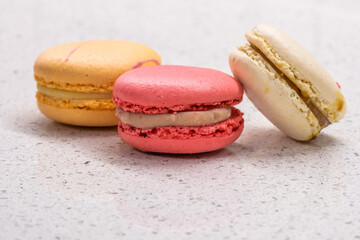 Colorful french cookies macarons set on pink background. Tasty fruit, almond sweet cookies, cake macaron. Holiday backdrop design.