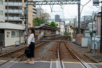 日本の電車の踏切を歩く女性