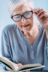 Glaucoma. Senior Woman a Reading Book, Having Ocular Tension.