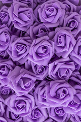 background of purple or lilac flowers. fake flowers. Artificial purple or lilac roses, foamiran roses.