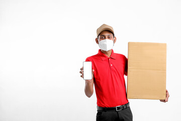 Fototapeta na wymiar Delivery Man Wearing Medical Mask and Showing Smartphone screen with Box in Hands. Home Delivery. Order Online Technology.