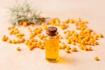 Bottle of sea buckthorn essential oil on grunge background