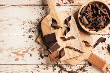 Delicious chocolate curls on white wooden background