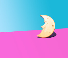 Wooden crescent moon face shape concept. Arrangement against purple and light blue background