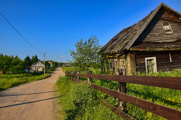 Rural dirt road through abandoned wooden houses