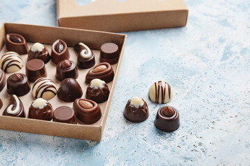Box with sweet chocolate candies on color background