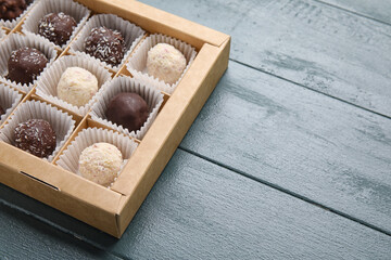 Box with sweet chocolate candies on wooden background
