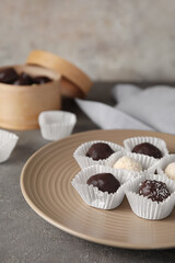 Plate with sweet chocolate candies on grunge background