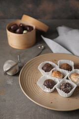 Plate with sweet chocolate candies on grunge background