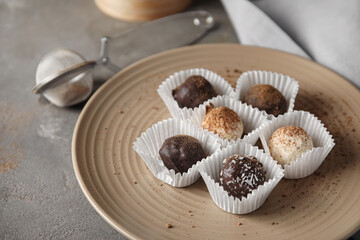 Plate with sweet chocolate candies on grunge background